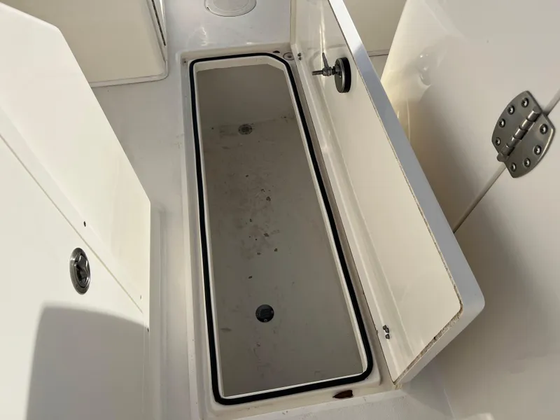 Slide: The Image of 2023 Cobia 220 Dual Console storage compartment, open and empty. - 19