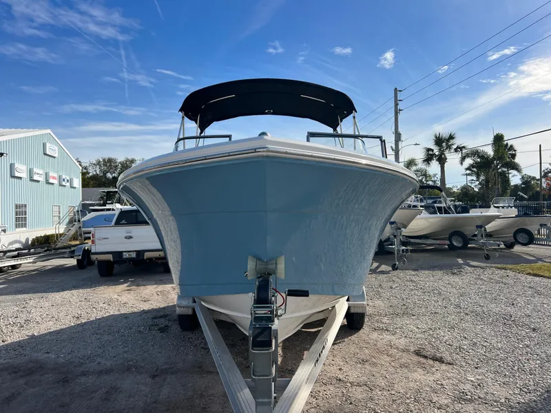 Slide: The Image of 2023 Cobia 220 Dual Console boat on trailer, front view, sunny day. - 2