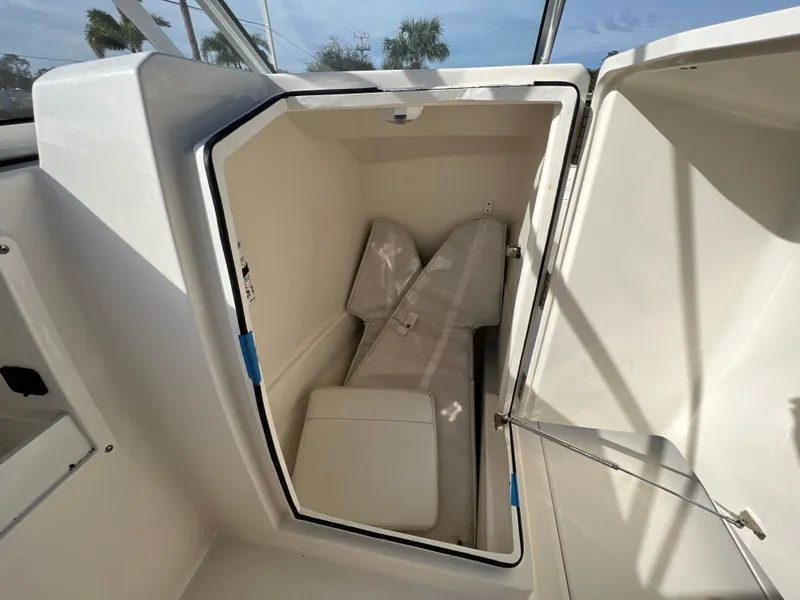 Slide: The Image of 2023 Cobia 220 Dual Console boat storage compartment with cushions inside. - 21