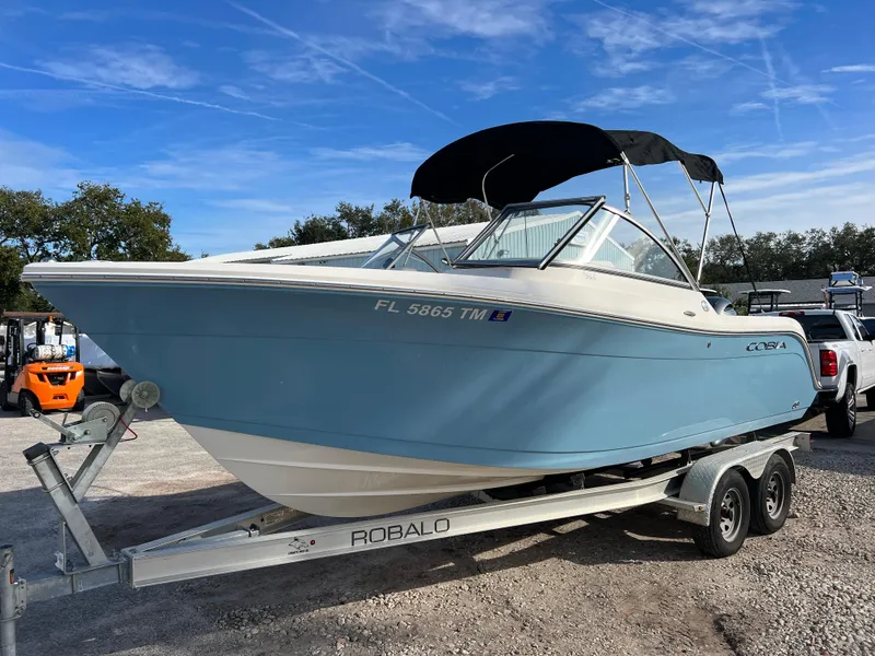 Slide: The Image of 2023 Cobia 220 Dual Console boat on Robalo trailer, parked outdoors. - 3