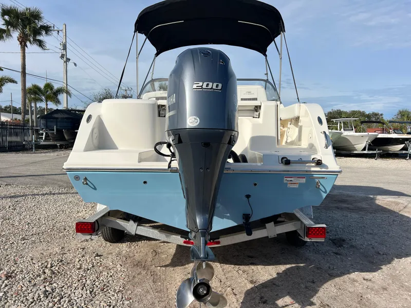 Slide: The Image of 2023 Cobia 220 Dual Console boat with Yamaha 200 engine, parked on a trailer. - 6