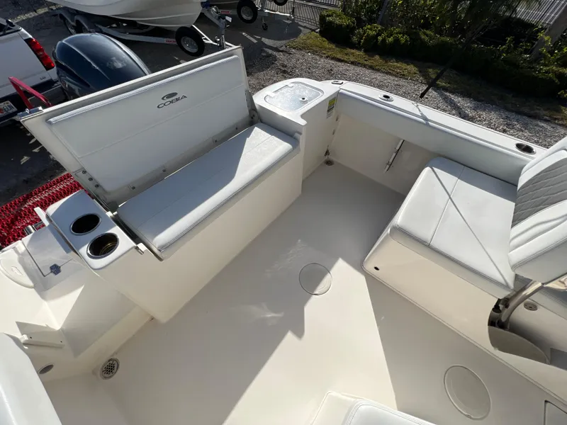 Slide: The Image of 2023 Cobia 220 Dual Console boat interior with white seating and cup holders. - 9