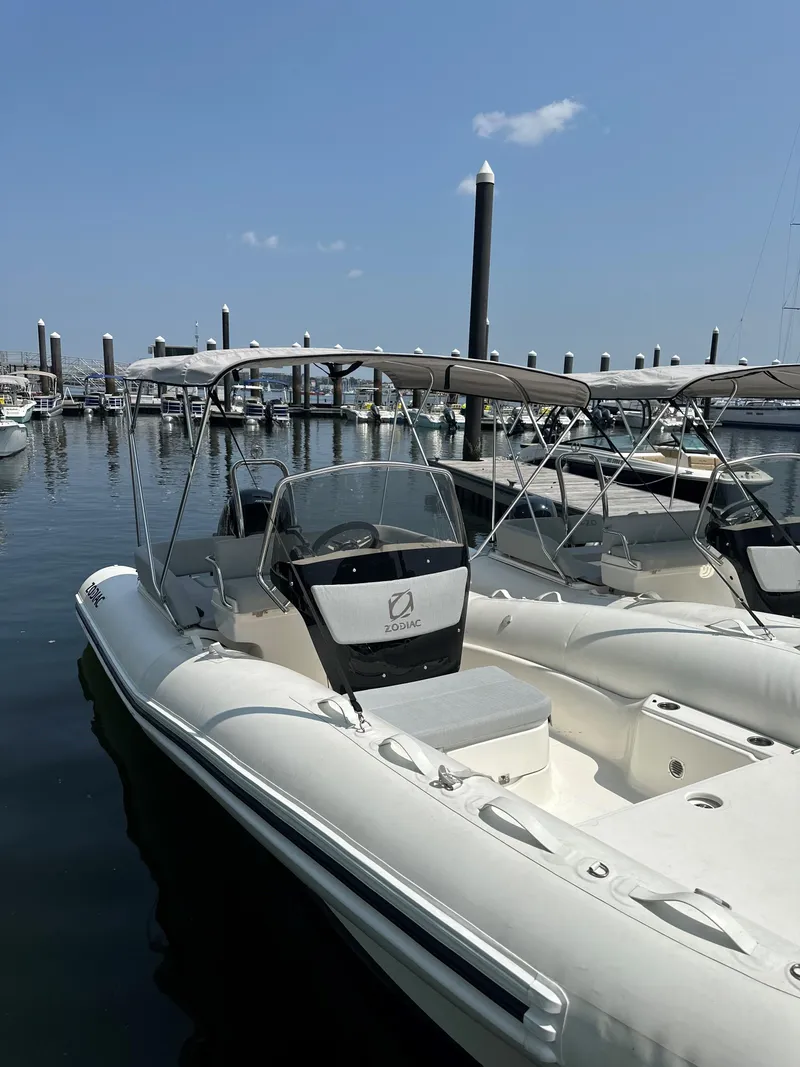Slide: The Image of 2023 Zodiac N-ZO 680 boat docked at marina under clear blue sky. - 10