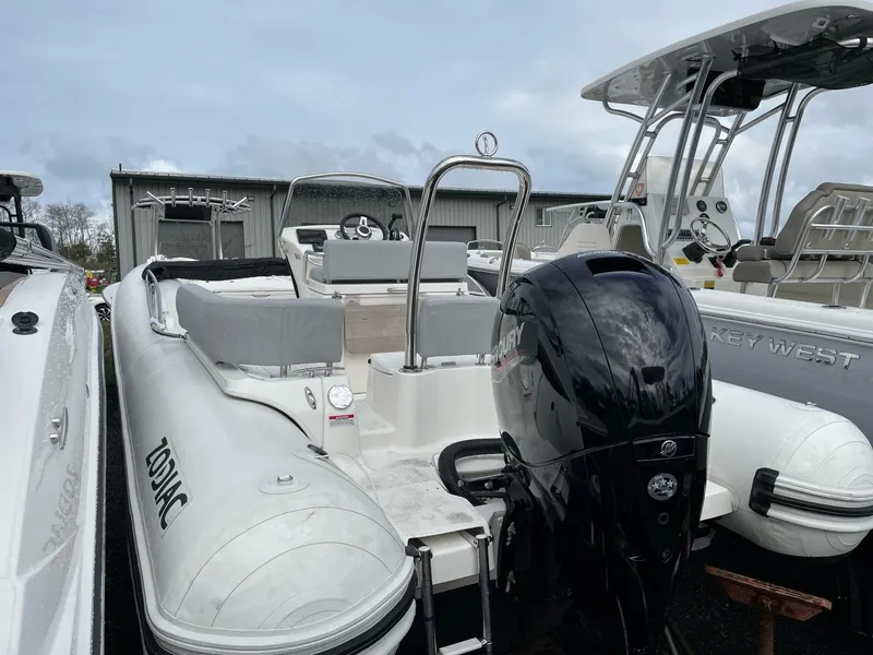 Slide: The Image of 2023 Zodiac N-ZO 680 boat with Mercury outboard motor, docked near other vessels. - 3