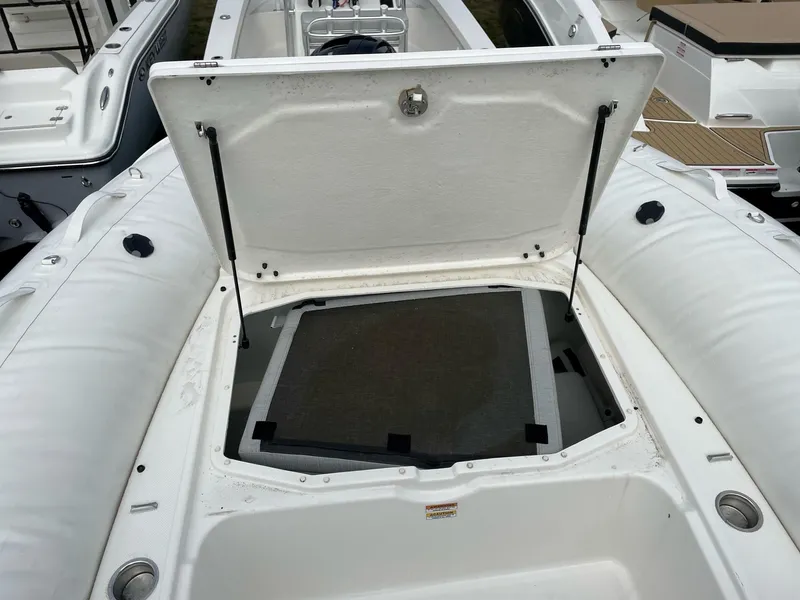 Slide: The Image of 2023 Zodiac N-ZO 680 boat storage compartment open, showcasing interior space. - 7