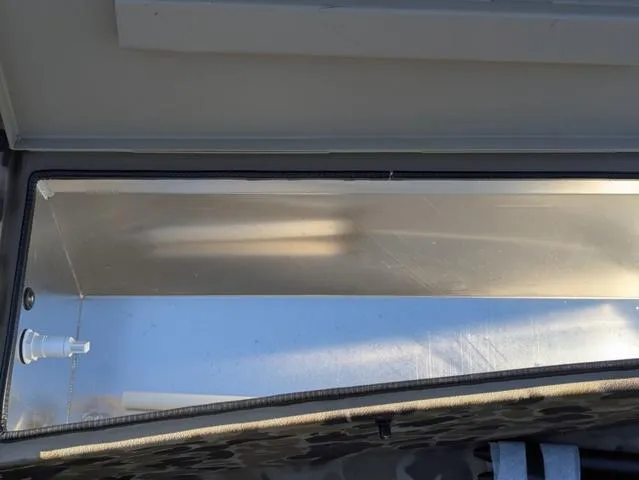 Slide: The Image of 2025 Excel 1854 Shallow Water F4 boat compartment, open and empty, with metallic interior. - 40