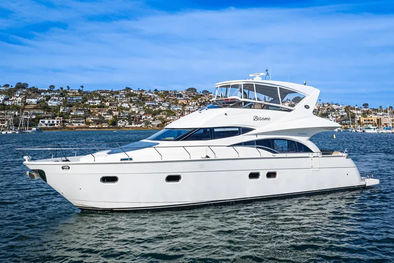 Slide: The Image of Luxurious 2004 Marquis 59 yacht cruising on a scenic waterfront. - 0