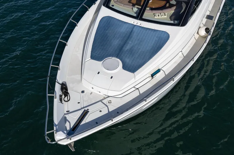 Slide: The Image of 2004 Marquis 59 yacht bow on water, featuring sleek design and spacious deck. - 1
