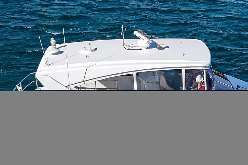 Slide: The Image of 2004 Marquis 59 yacht cruising on blue ocean waters. - 10