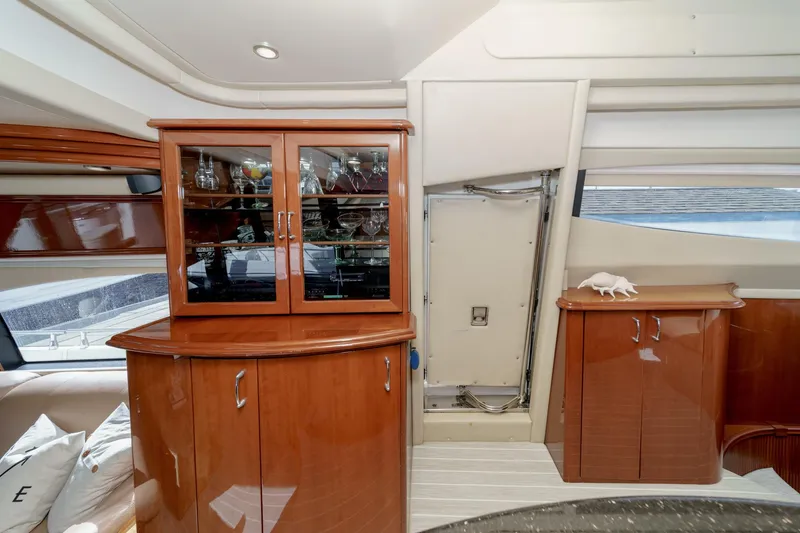 Slide: The Image of Luxurious interior of 2004 Marquis 59 yacht with polished wood cabinets and glassware display. - 19