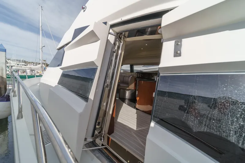 Slide: The Image of 2004 Marquis 59 yacht exterior with open cabin door, docked at marina. - 20