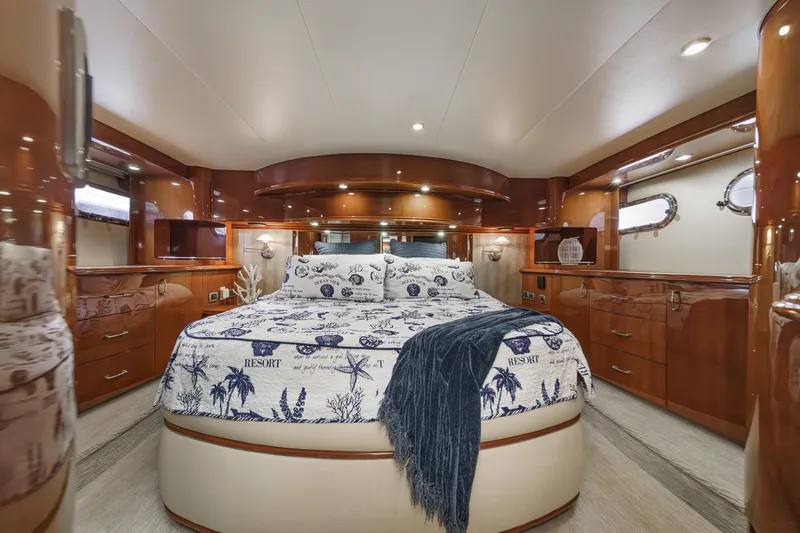 Slide: The Image of Luxurious 2004 Marquis 59 yacht bedroom with elegant wood finishes and nautical-themed bedding. - 23