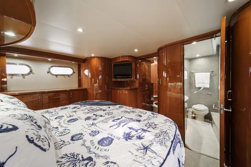 Slide: The Image of Luxurious 2004 Marquis 59 yacht bedroom with elegant wood finishes and ensuite bathroom. - 25