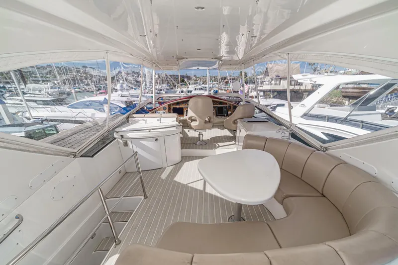 Slide: The Image of Luxurious 2004 Marquis 59 yacht interior with seating and helm, docked at marina. - 37