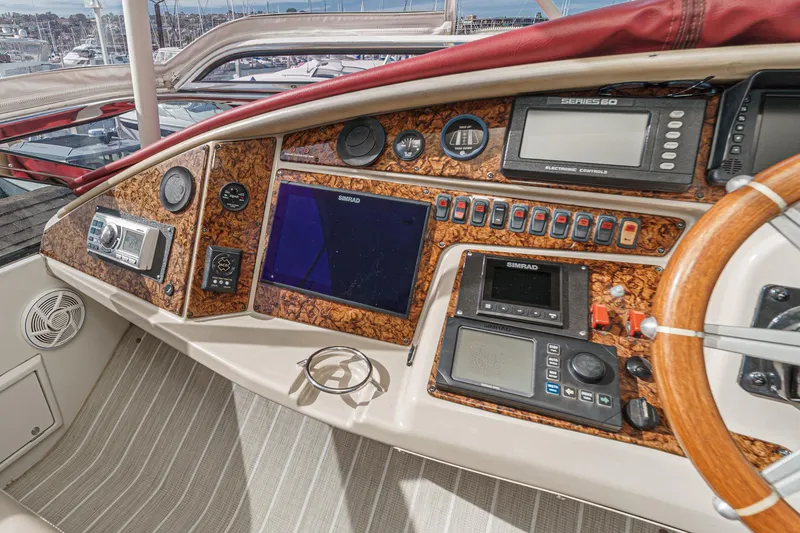 Slide: The Image of 2004 Marquis 59 yacht dashboard with navigation instruments and wood accents. - 40