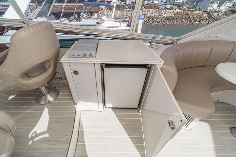 Slide: The Image of 2004 Marquis 59 yacht interior with seating, mini fridge, and counter. - 42