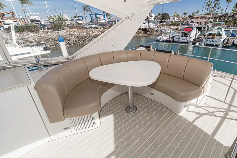 Slide: The Image of Luxurious 2004 Marquis 59 yacht with elegant seating area and scenic marina view. - 46