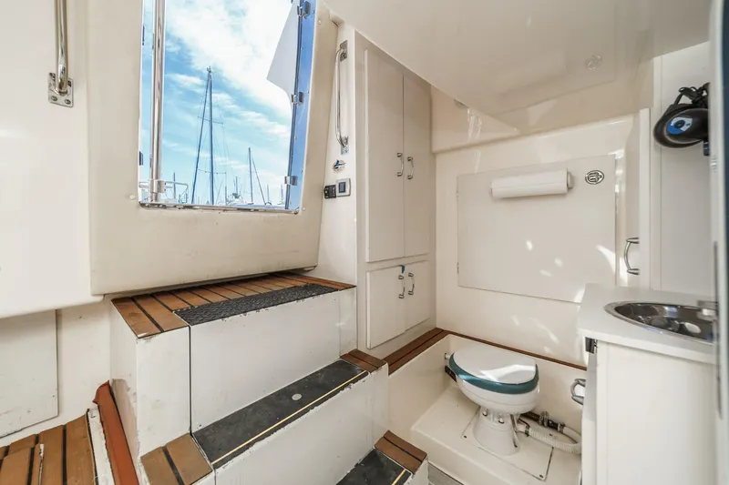 Slide: The Image of Interior of a 2004 Marquis 59 yacht, featuring a compact bathroom and wooden steps. - 48