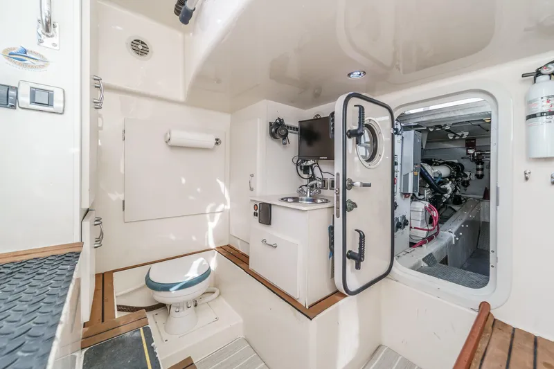 Slide: The Image of Engine room and bathroom of 2004 Marquis 59 yacht, featuring modern equipment and fixtures. - 49