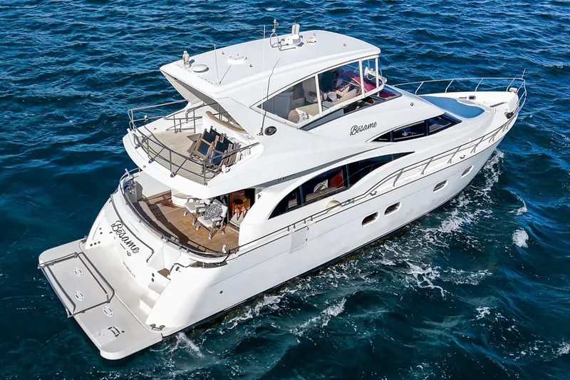 Slide: The Image of 2004 Marquis 59 yacht cruising on open water, showcasing sleek design and luxury features. - 5