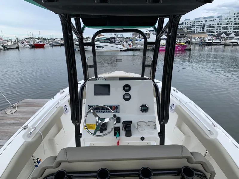 Slide: The Image of 2024 Key West 239 FS boat dashboard at marina, featuring modern controls and steering wheel. - 2