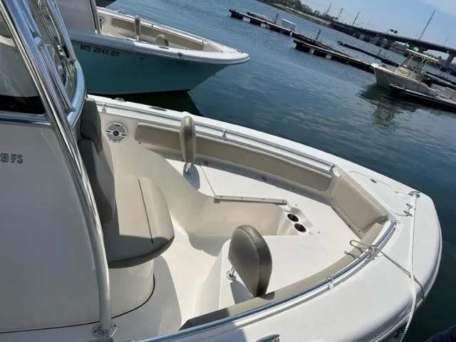 Slide: The Image of 2022 Key West 219 FS boat docked in a marina, showcasing seating and open deck. - 2