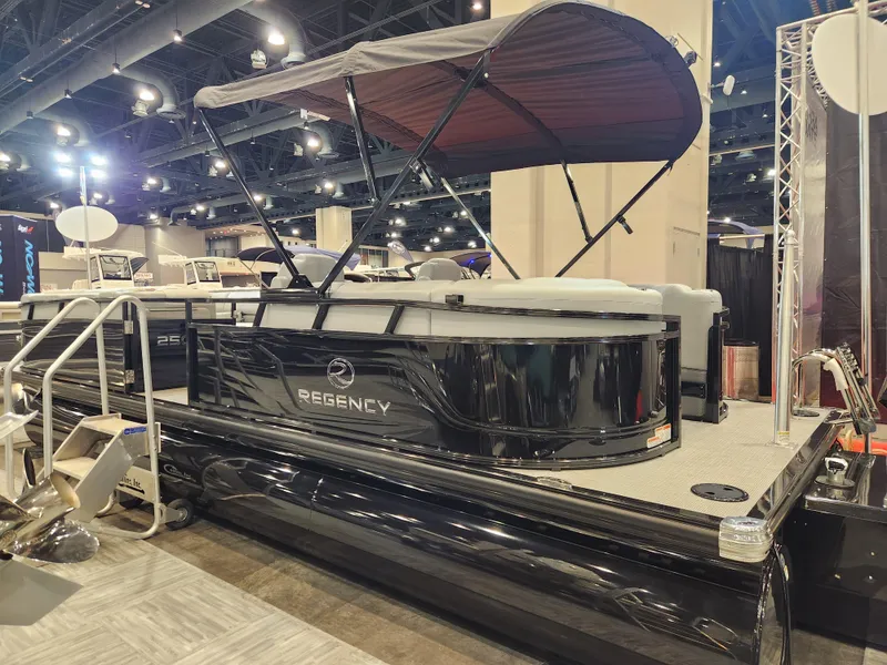 Slide: The Image of 2025 Regency 250 LE3 pontoon boat displayed indoors with canopy. - 3