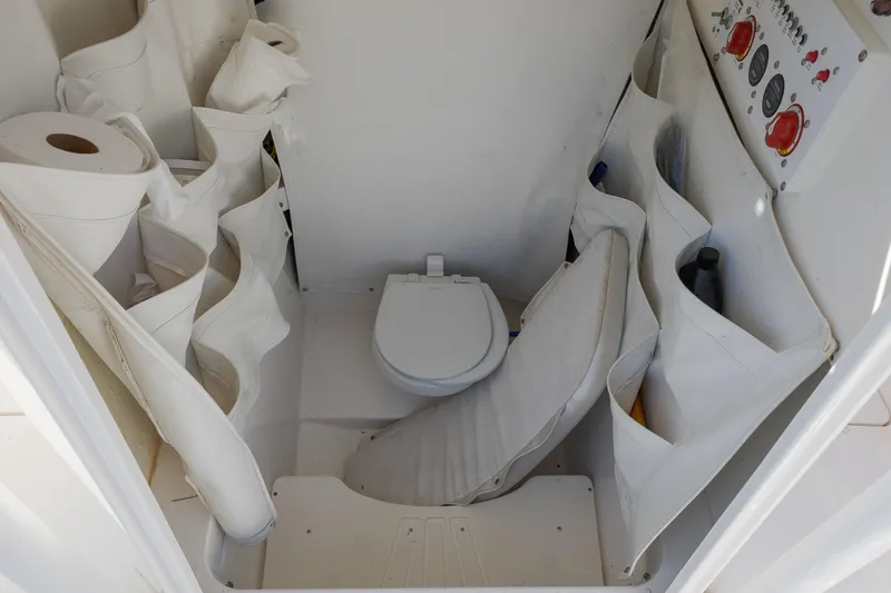 Slide: The Image of 2019 Wellcraft 262 Fisherman boat interior with compact toilet and storage compartments. - 16
