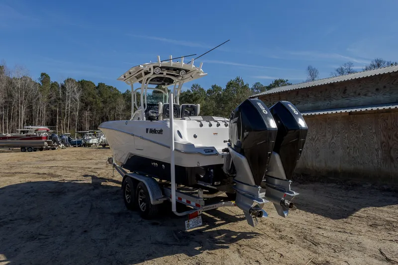 Slide: The Image of 2019 Wellcraft 262 Fisherman boat on trailer, dual outboard motors, parked outdoors. - 8
