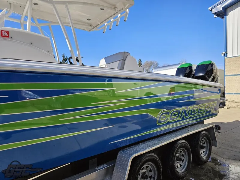 Slide: The Image of Concept 36' CC 2014 boat with blue and green design on a trailer. - 29
