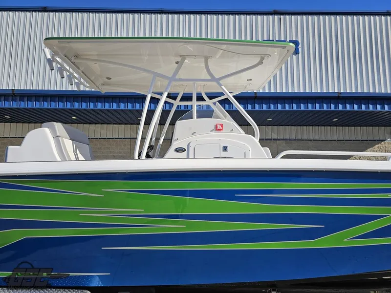 Slide: The Image of 2014 Concept 36' CC boat with vibrant blue and green design, docked near a building. - 4