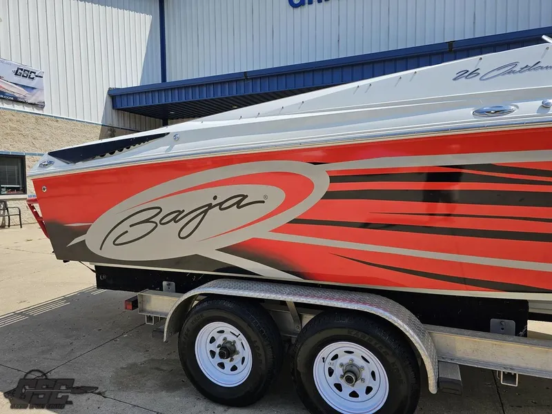Slide: The Image of 2007 Baja 26 Outlaw boat with red and white design on a trailer. - 10