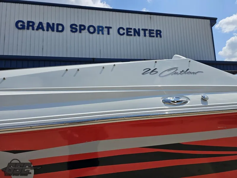 Slide: The Image of 2007 Baja 26 Outlaw boat at Grand Sport Center, featuring sleek red and black design. - 12