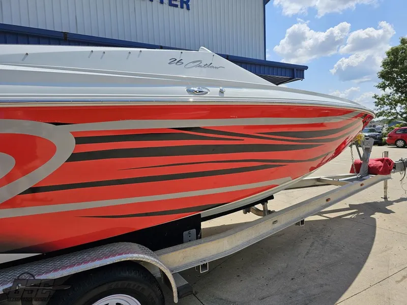 Slide: The Image of 2007 Baja 26 Outlaw boat with red and black graphics on a trailer. - 13