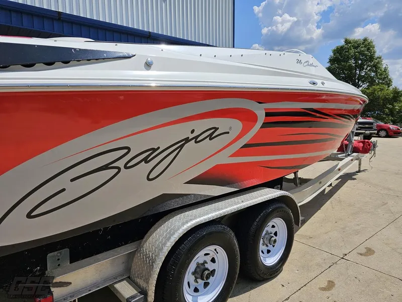 Slide: The Image of 2007 Baja 26 Outlaw boat with red and white design on a trailer. - 15