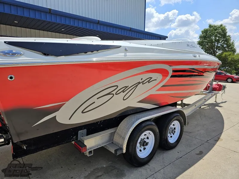 Slide: The Image of 2007 Baja 26 Outlaw boat on trailer, red and white design, parked outdoors. - 16
