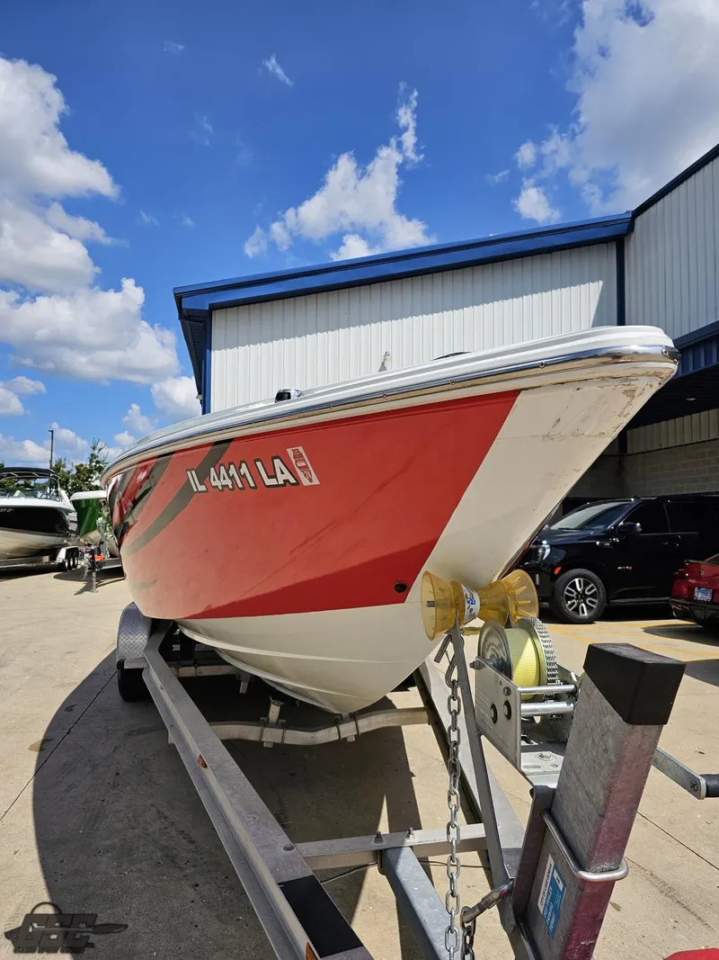 Slide: The Image of 2007 Baja 26 Outlaw boat on trailer, parked outdoors under a blue sky. - 18
