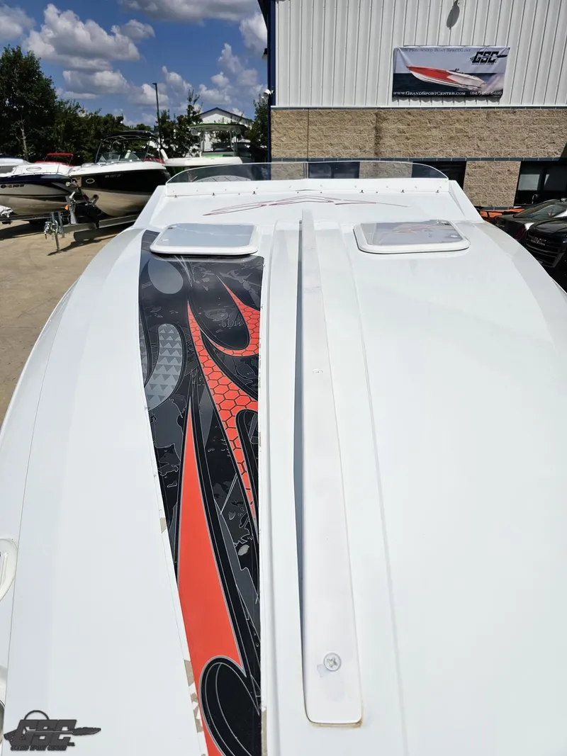 Slide: The Image of 2007 Baja 26 Outlaw boat with sleek design and vibrant graphics, docked outdoors. - 20