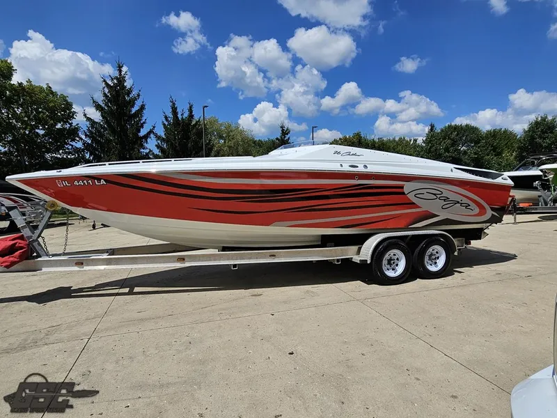 Slide: The Image of 2007 Baja 26 Outlaw speedboat with red and black graphics on a trailer, under a blue sky. - 22