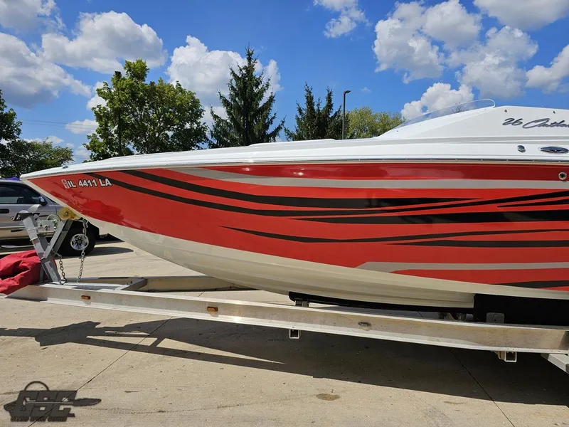Slide: The Image of 2007 Baja 26 Outlaw boat with red and black stripes on a trailer, under a blue sky. - 23