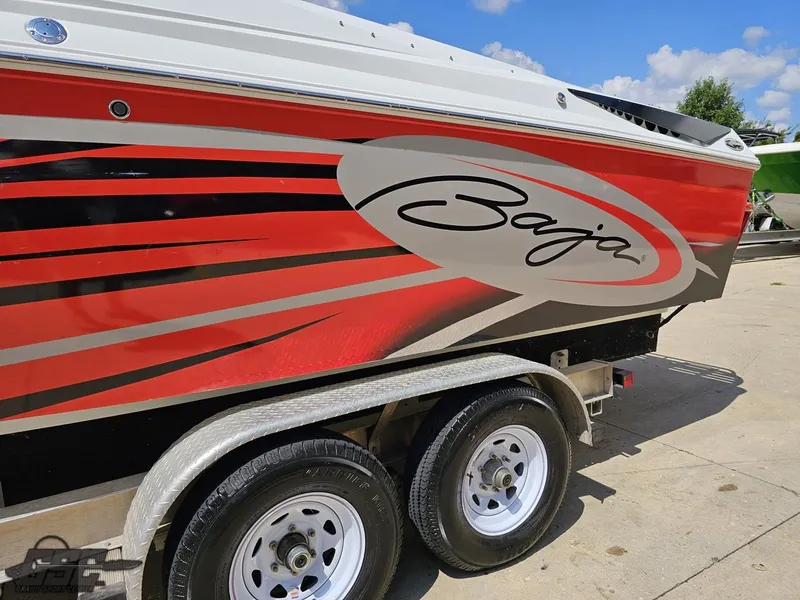 Slide: The Image of 2007 Baja 26 Outlaw boat with red and black graphics on a trailer. - 25