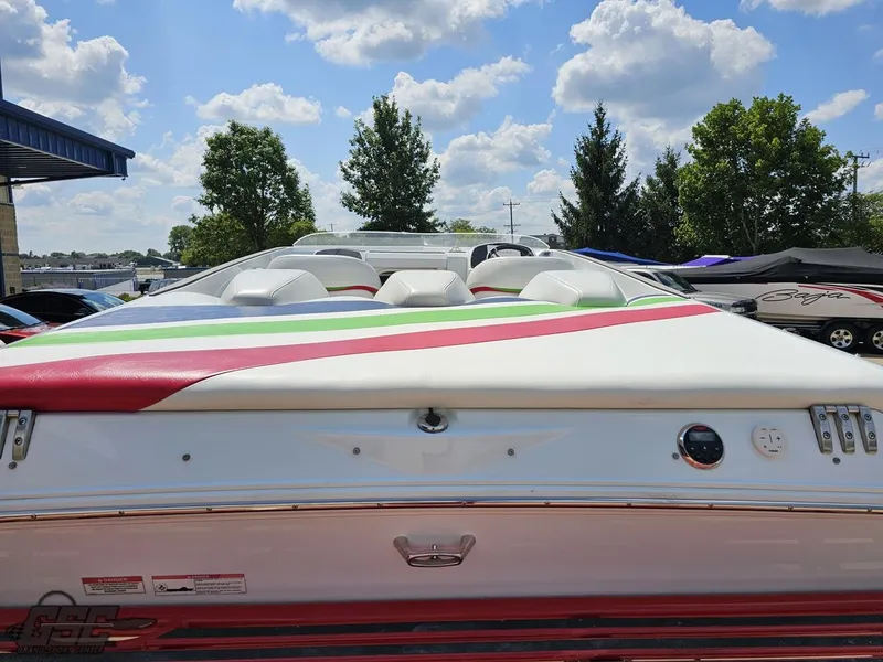 Slide: The Image of 2007 Baja 26 Outlaw boat with colorful seating, parked outdoors under a blue sky. - 37