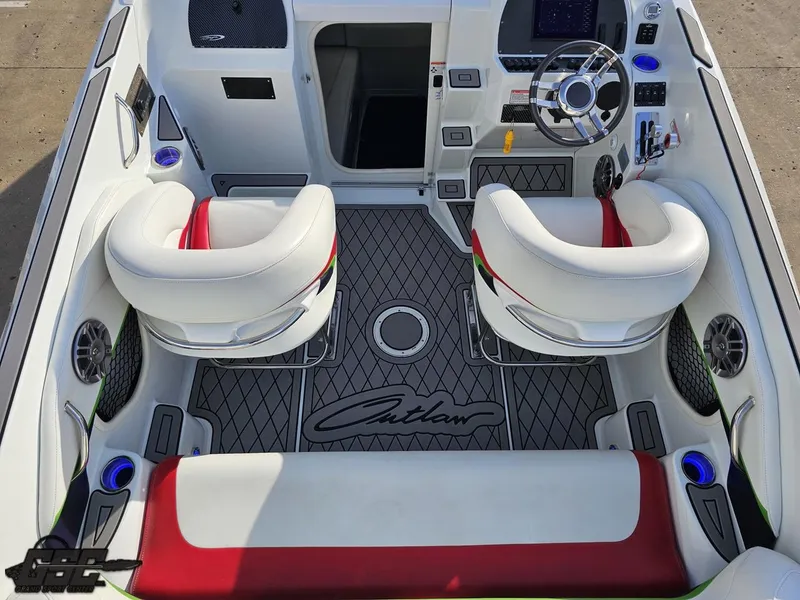 Slide: The Image of 2007 Baja 26 Outlaw boat interior with white and red seating, modern dashboard, and custom flooring. - 46