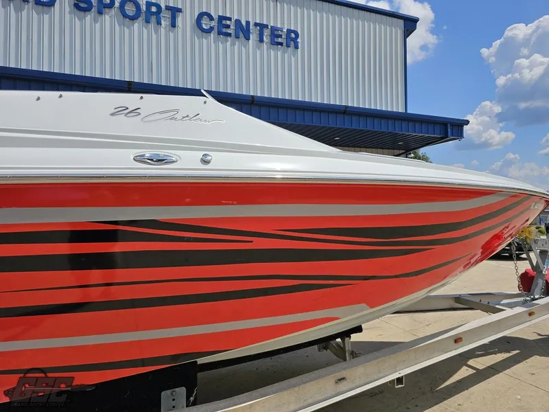 Slide: The Image of 2007 Baja 26 Outlaw boat with red and black stripes at a sport center. - 5