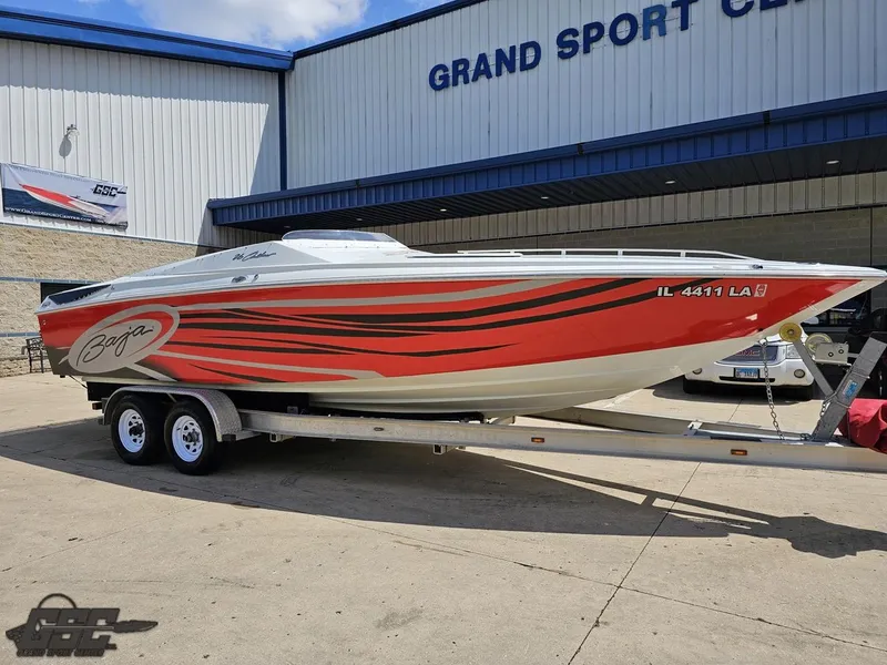Slide: The Image of 2007 Baja 26 Outlaw boat with red and black graphics on a trailer at Grand Sport Center. - 7