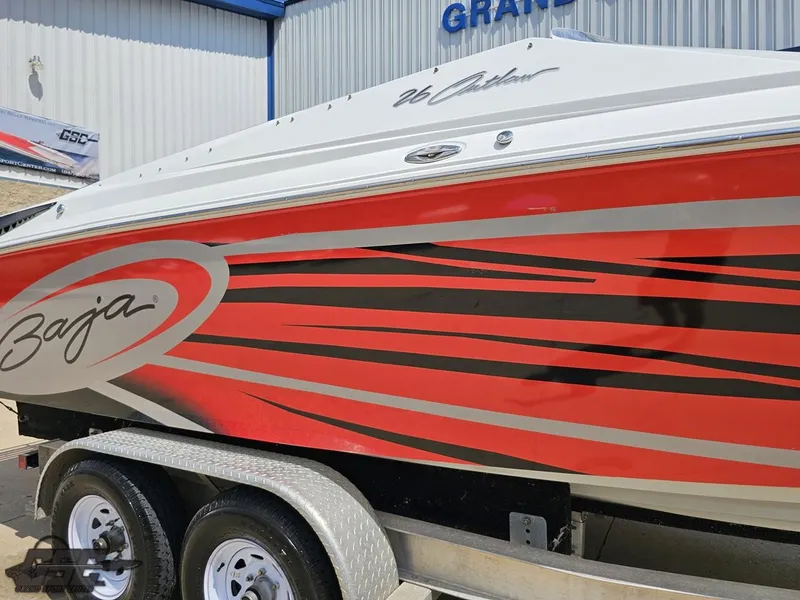Slide: The Image of 2007 Baja 26 Outlaw boat with red and black graphics on a trailer. - 9