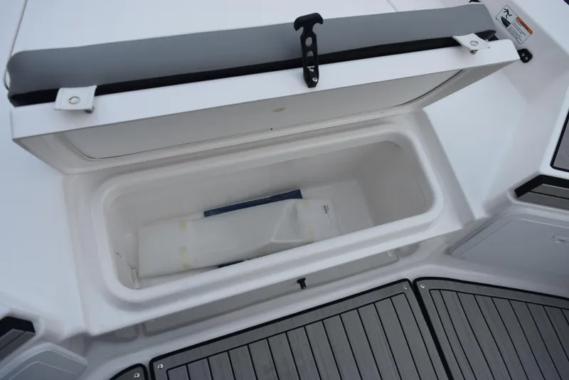 Slide: The Image of 2025 Yamaha Boats 195 FSH Sport storage compartment with open lid, showcasing interior space. - 13