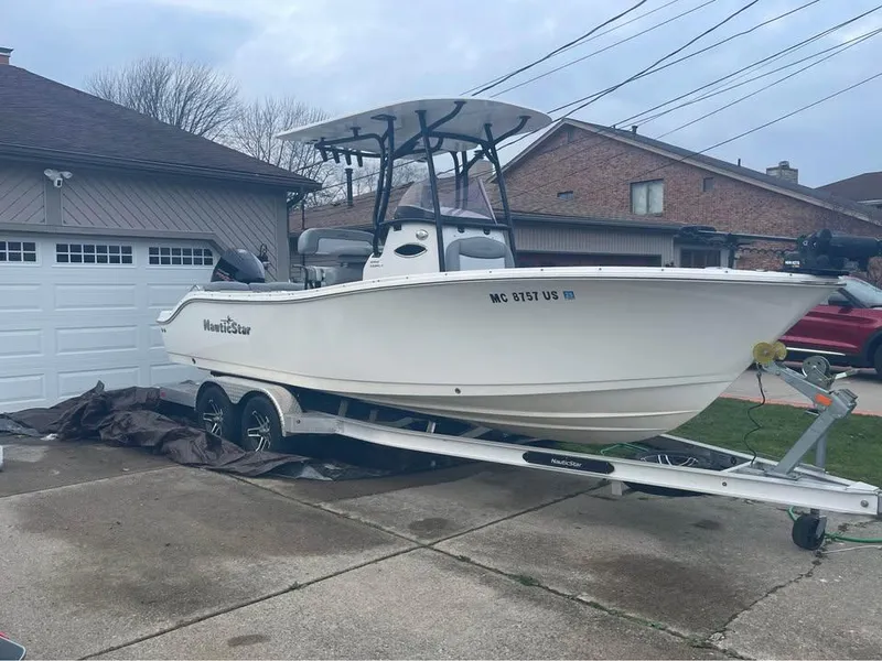 Slide: The Image of 2022 NauticStar 2302 Legacy boat on trailer in residential driveway. - 1