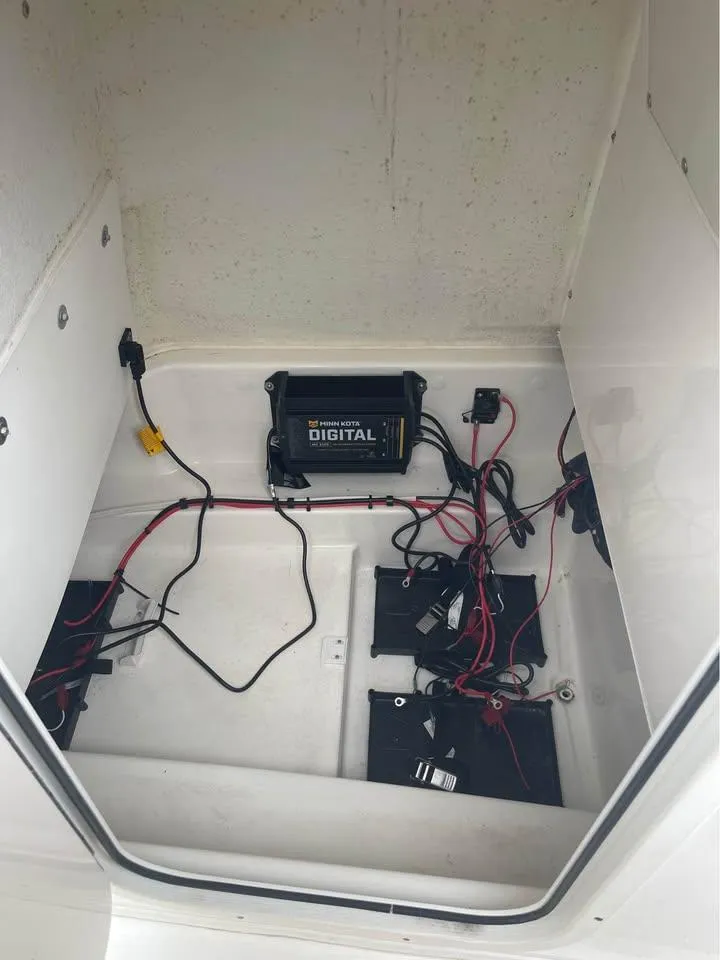 Slide: The Image of 2022 NauticStar 2302 Legacy boat battery compartment with wiring and digital charger. - 12