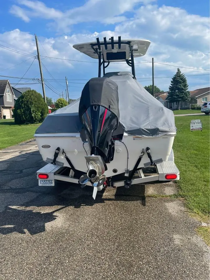 Slide: The Image of 2022 NauticStar 2302 Legacy boat with covered engine, parked on a residential street. - 4